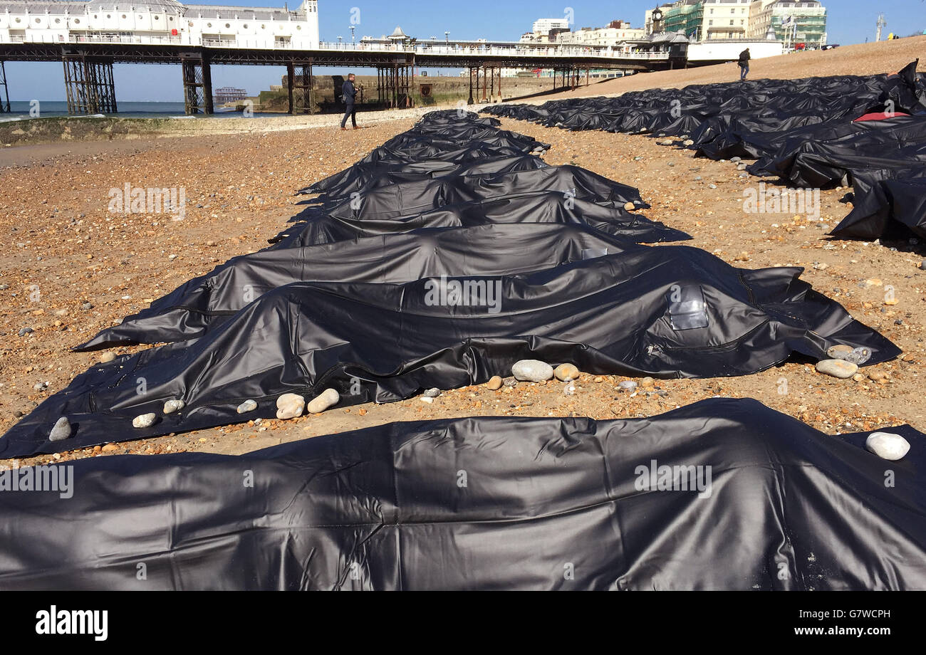 Zweihundert schwarze Leichensäcke Reihen sich am Brighton Beach in East Sussex von Aktivisten aneinander, die Großbritanniens „schändliche“ Reaktion auf die Migrationskrise im Mittelmeer hervorheben. Stockfoto
