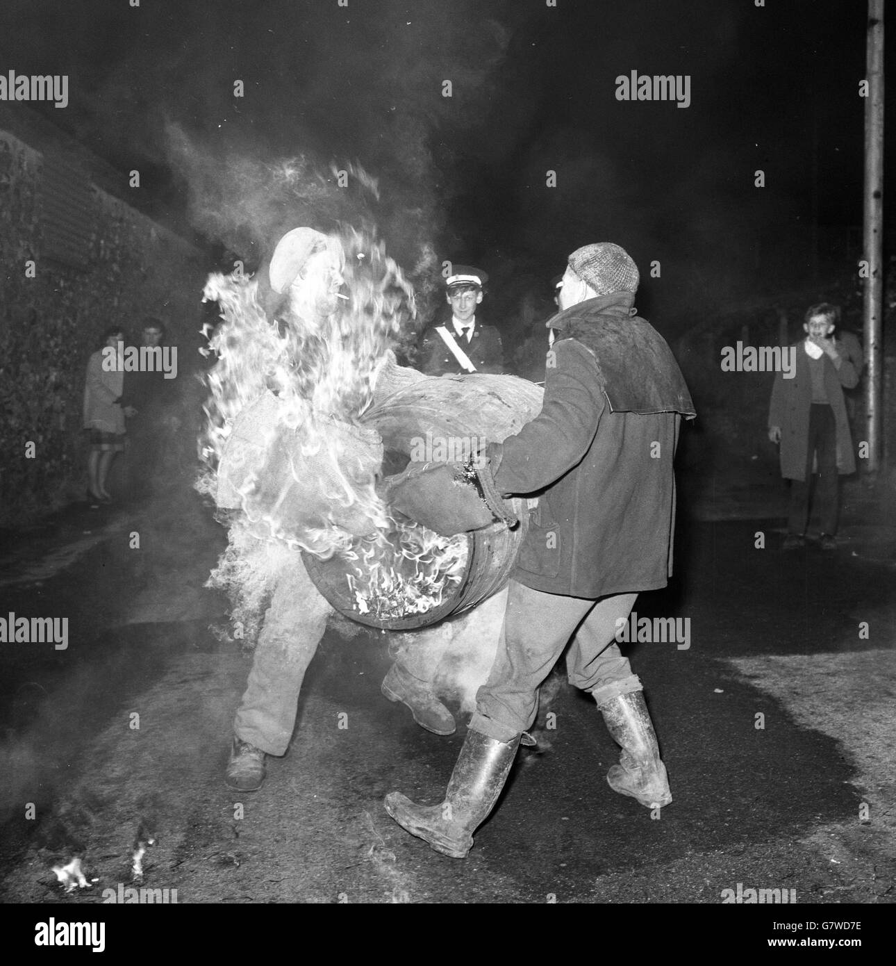 Tar Barrel Burning Ceremony - Ottery St Mary's. Die Schlacht beginnt, als ein Mann versucht, die flammende Last von einem anderen zu fangen. Stockfoto
