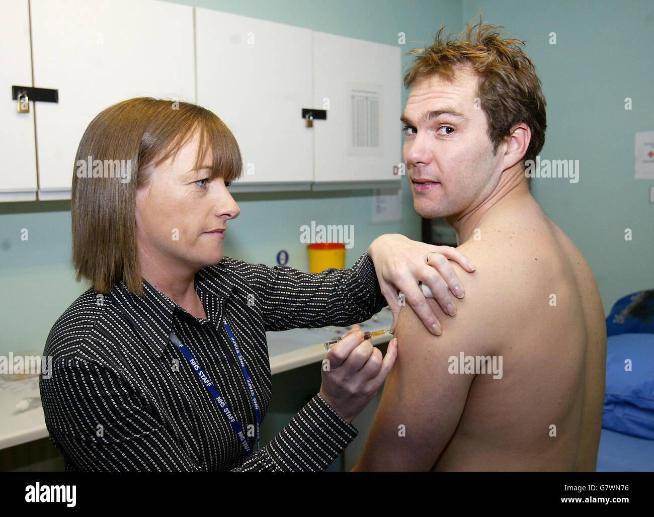 Tranmere Rovers Kapitän Jason McAteer wird von Krankenschwester Barbara Robinson einen MMR Jab gegeben. Eine ganze Mannschaft von Profifußballer erhielt den MMR-Impfstoff, nachdem sich zwei Spieler an Mumps erkrankt hatten. Tranmere Rovers FC hielt die Massenimmunisierung Sitzung, nachdem zwei Jugendliche Lehrlinge ging mit dem Virus. Stockfoto