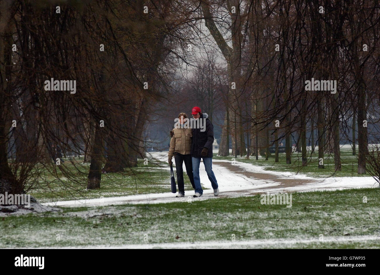 Ein paar Spaziergang durch Londons schneebedeckten Hyde Park. Stockfoto