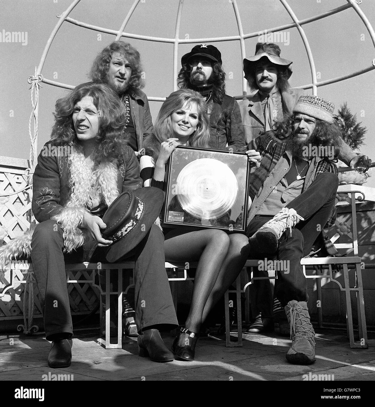 Die Filmschauspielerin Julie Ege hält das Gold Album, das sie im Auftrag von Warner Reprise der Jethro Tull Popgruppe im Dorchester Hotel präsentierte. Gruppenmitglieder mit ihr hier sind: John Evan (erste Reihe, links): Ian Anderson (erste Reihe, rechts) und hintere Reihe (von links nach rechts): Martin Lancelot Barre: Jeffrey Hammond-Hammond und Clive Bunker. Stockfoto