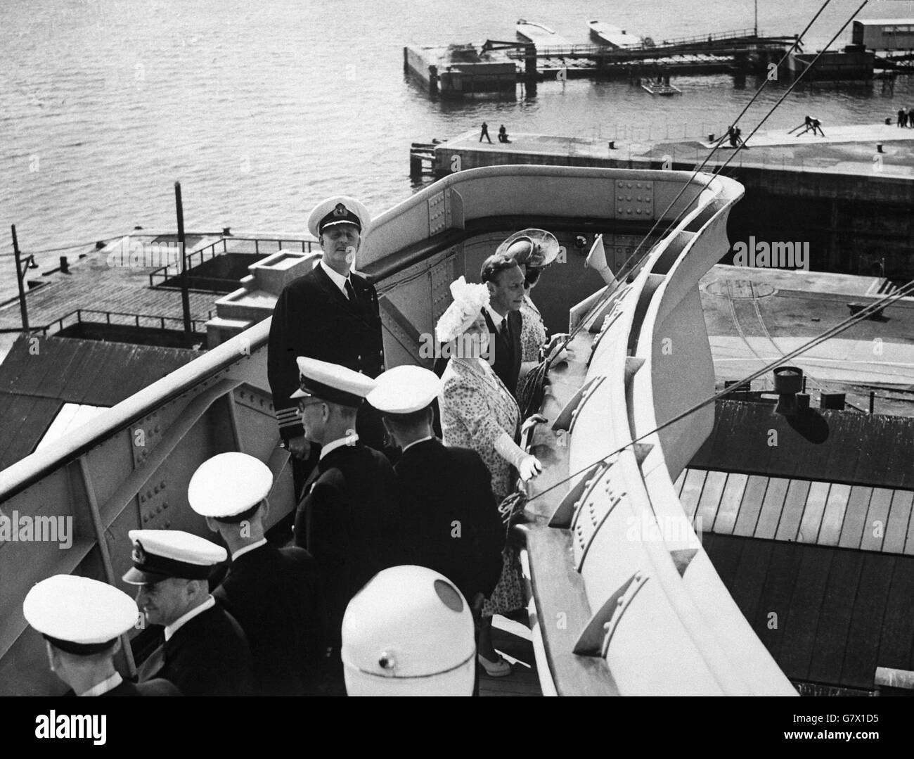 H.M der König und die Königin mit Kapitän John Ford, Kommandant der "Königin Elizabeth" auf der Brücke. Ihre Majestäten der König und die Königin, begleitet von H.R.H Prinzessin Margaret, besuchten Southampton heute (Mittwoch), um die Cunard White Star Liner 'Queen Elizabeth' zu sehen. Die königliche Partei inspizierte das neue Porträt von H.M. der Königin, das in der Hauptlounge des Schiffes hängt. Stockfoto