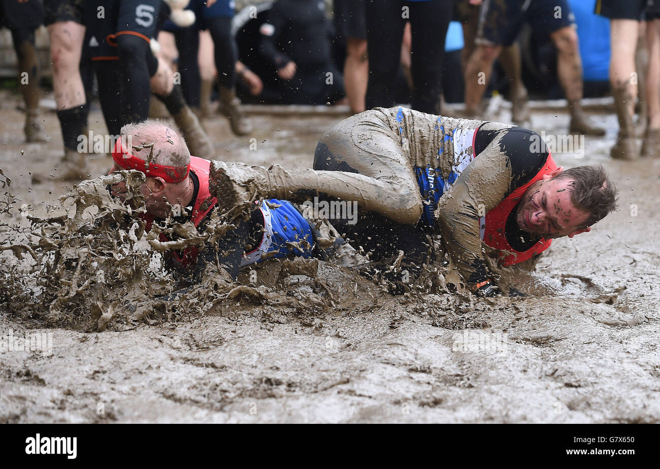 Teilnehmer schlüpfen und rutschen im Schlamm während des Tough Mudder London West in Culden Faw in Henley-on-Thames, Oxfordshire. Stockfoto