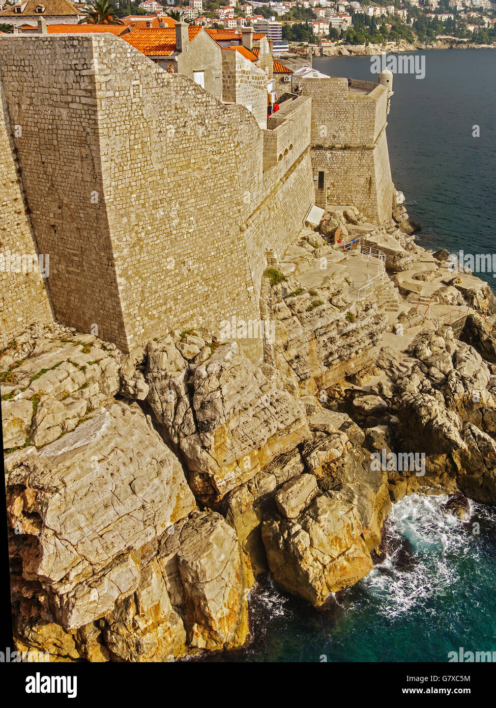 Sheer Stadtmauer bis hin zu Felsen und Meer Dubrovnik Kroatien Stockfoto