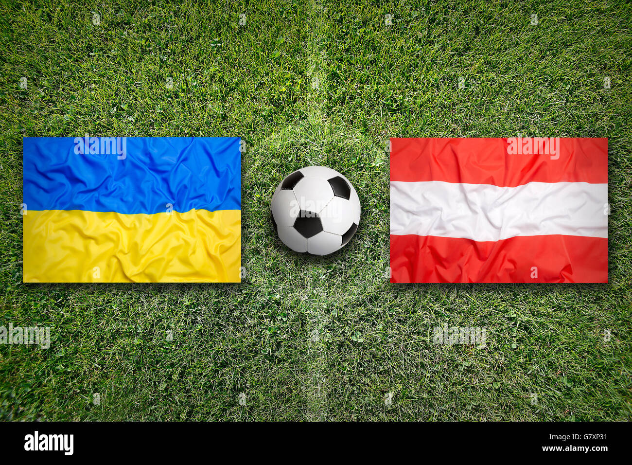 Ukraine gegen Österreich Flaggen auf grüne Fußballplatz Stockfoto