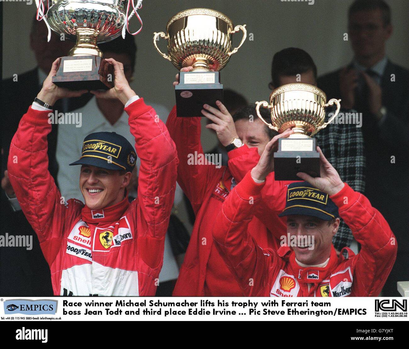 Rennsieger Michael Schumacher hebt seine Trophäe mit dem Ferrari-Team an Boss Jean Todt und Dritter Eddie Irvine Stockfoto