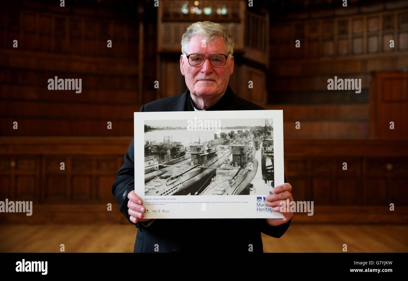 FR Arthur O'Reilly, in der Guildhall, Londonderry, hält ein Foto von deutschen U-Booten, die nach dem Ende des Zweiten Weltkriegs vor 70 Jahren an diesem Wochenende in Lishly auf dem Fluss Foyle in Londonderry, Nordirland, angedockt sind. Stockfoto