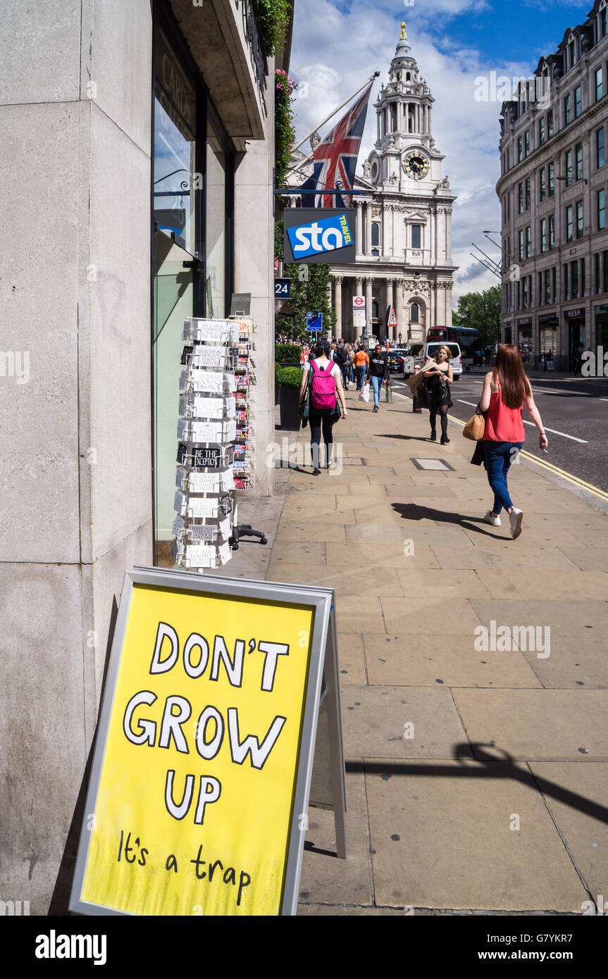Sandwichbrett vor einem Geschäft "nicht erwachsen zu werden, es ist eine Falle", St. Pauls Ludgate Hill, London, England Stockfoto