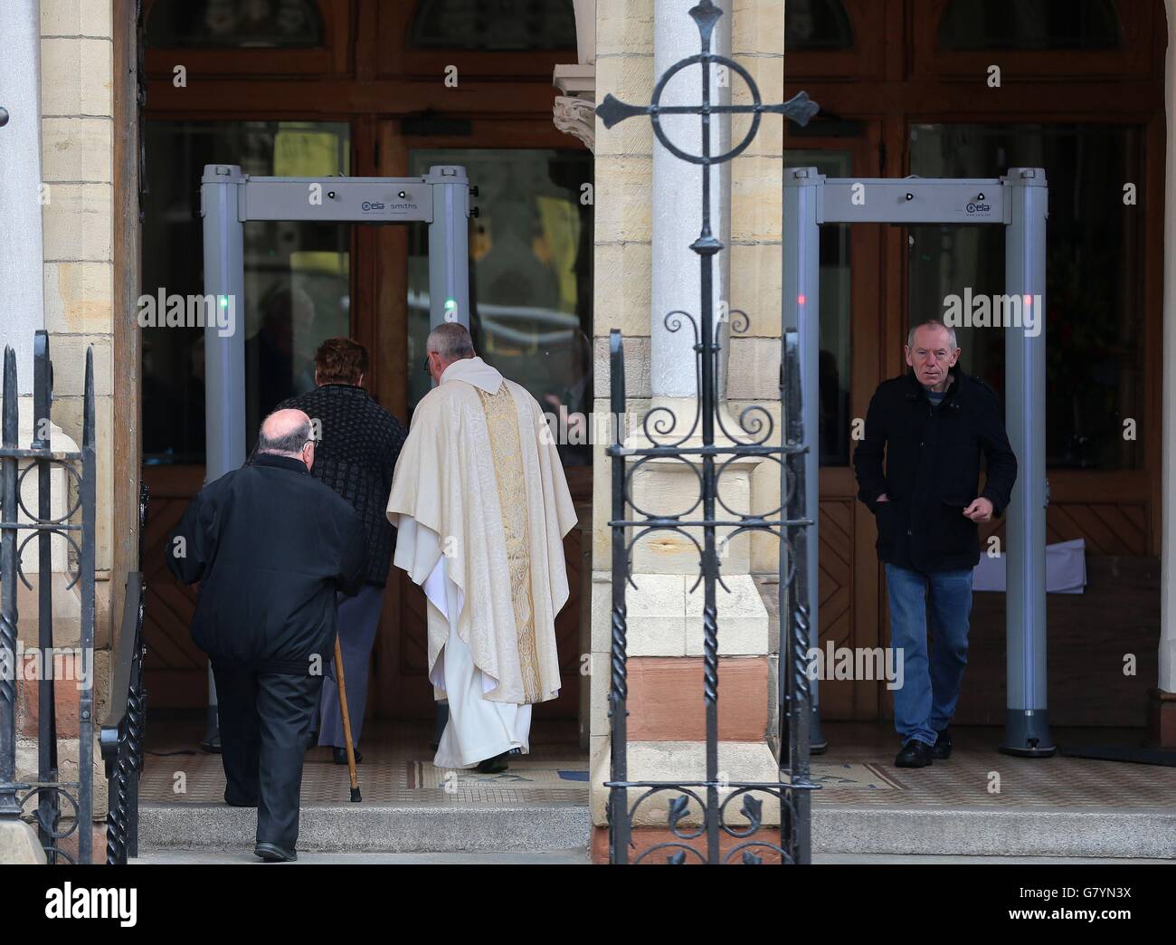 Massengänger passieren Metalldetektoren in der St. Patrick's Church in Belfast, bevor der Prinz von Wales und die Herzogin von Cornwall einen geplanten Besuch abstatten. Stockfoto