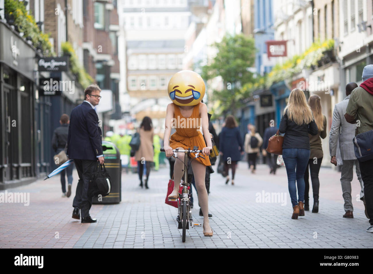 Drei Menschen, die als Emoji-Figuren gekleidet sind, reisen durch London, wie eine neue Studie von TalkTalk Mobile anlässlich der Einführung der preisgünstigsten unbegrenzten mobilen SIM-Karte Großbritanniens zeigt, dass Emoji schneller angenommen wird als jede andere Sprache in der Geschichte, 8 von 10 Briten nutzen nun die bunten Symbole, um zu kommunizieren. Stockfoto