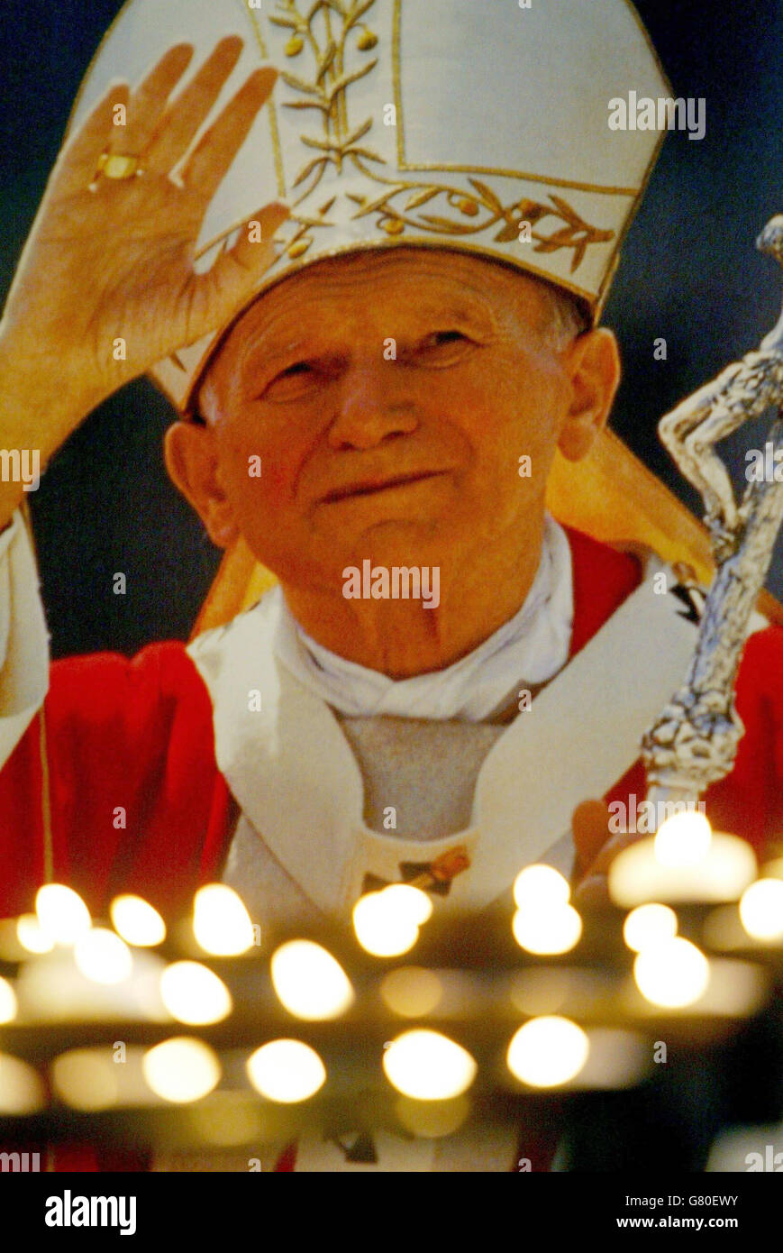 Kerzen in der Westminister Kathedrale vor einem Bild des Papstes angezündet. Stockfoto
