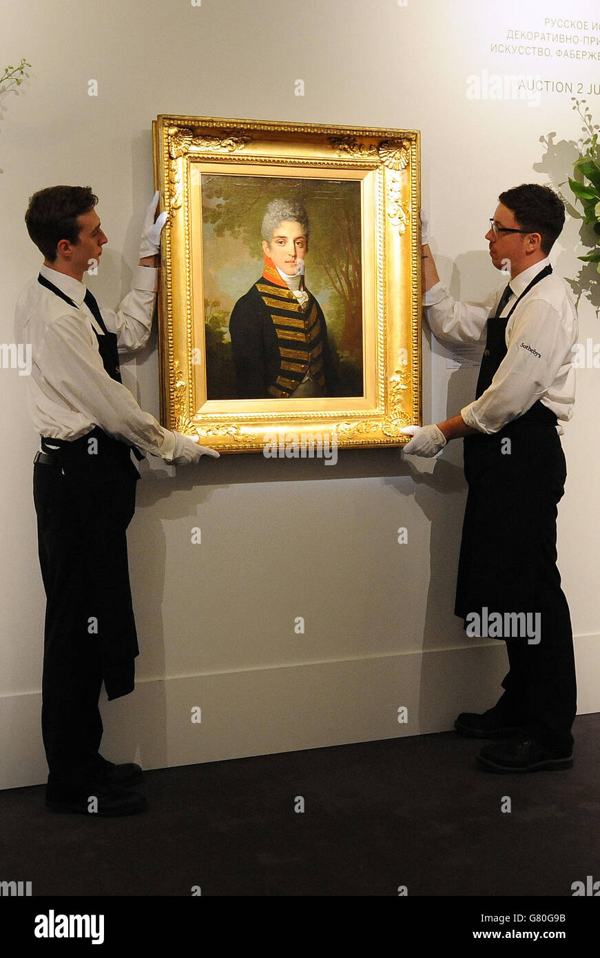 Mitarbeiter der Galerie halten „Portrait of Ardalion Petrovich Novosiltsev“ (1807), ein Öl auf Leinwand von Vladimir Borovikovsky, geschätzt auf £1,400,000 bis £1,800,000, während einer Fotoausstellung für Sothebys Verkauf russischer Kunstwerke, Faberge und Ikonen in der New Bond Street, London, die am 2. Juni stattfinden soll. Stockfoto