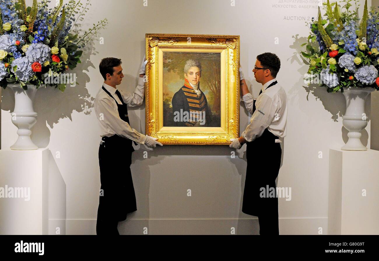 Mitarbeiter der Galerie halten „Portrait of Ardalion Petrovich Novosiltsev“ (1807), ein Öl auf Leinwand von Vladimir Borovikovsky, geschätzt auf £1,400,000 bis £1,800,000, während einer Fotoausstellung für Sothebys Verkauf russischer Kunstwerke, Faberge und Ikonen in der New Bond Street, London, die am 2. Juni stattfinden soll. Stockfoto