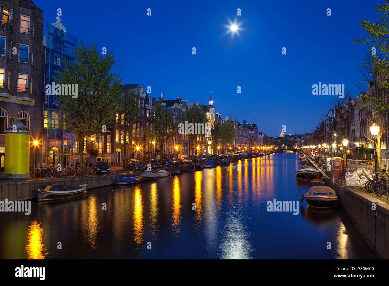 Nacht Schuss auf die Prinsengracht in der Innenstadt von Amsterdam, Niederlande mit Vollmond scheint und im Wasser spiegelt. Stockfoto