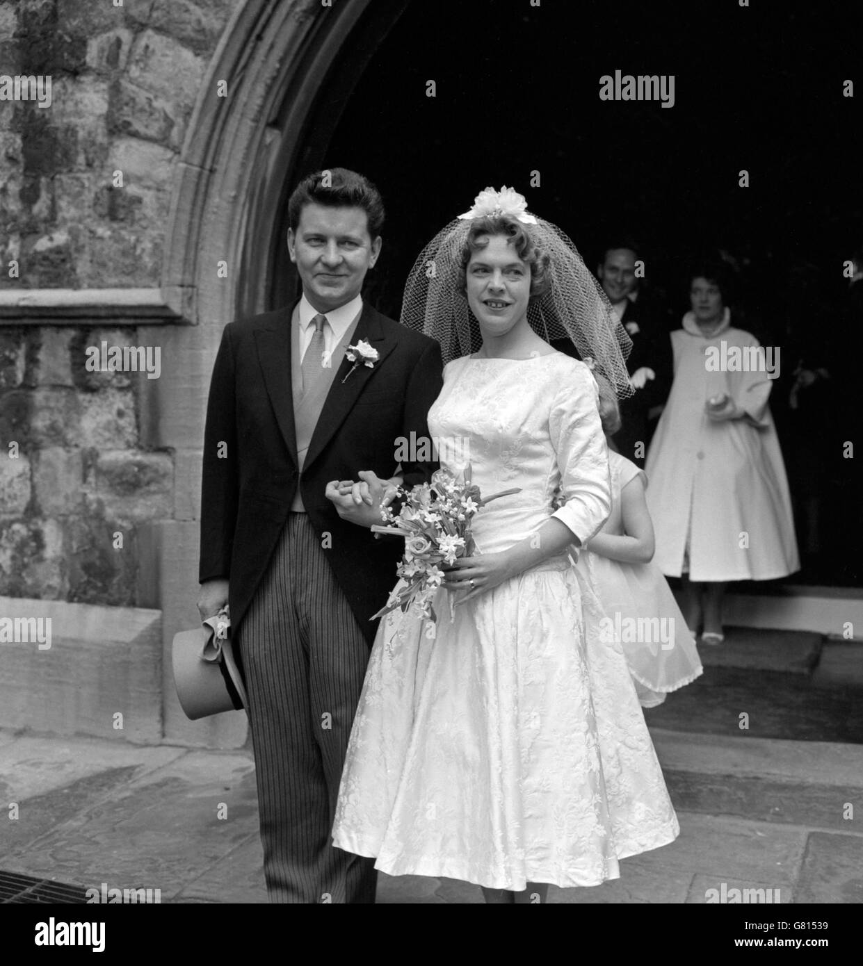 Richard Baker, Fernsehsprecher der BBC, und seine Braut - ehemals Margaret Martin - verlassen ihre Hochzeit in der St. Mary the Boltons Church in Kensington, London. Stockfoto