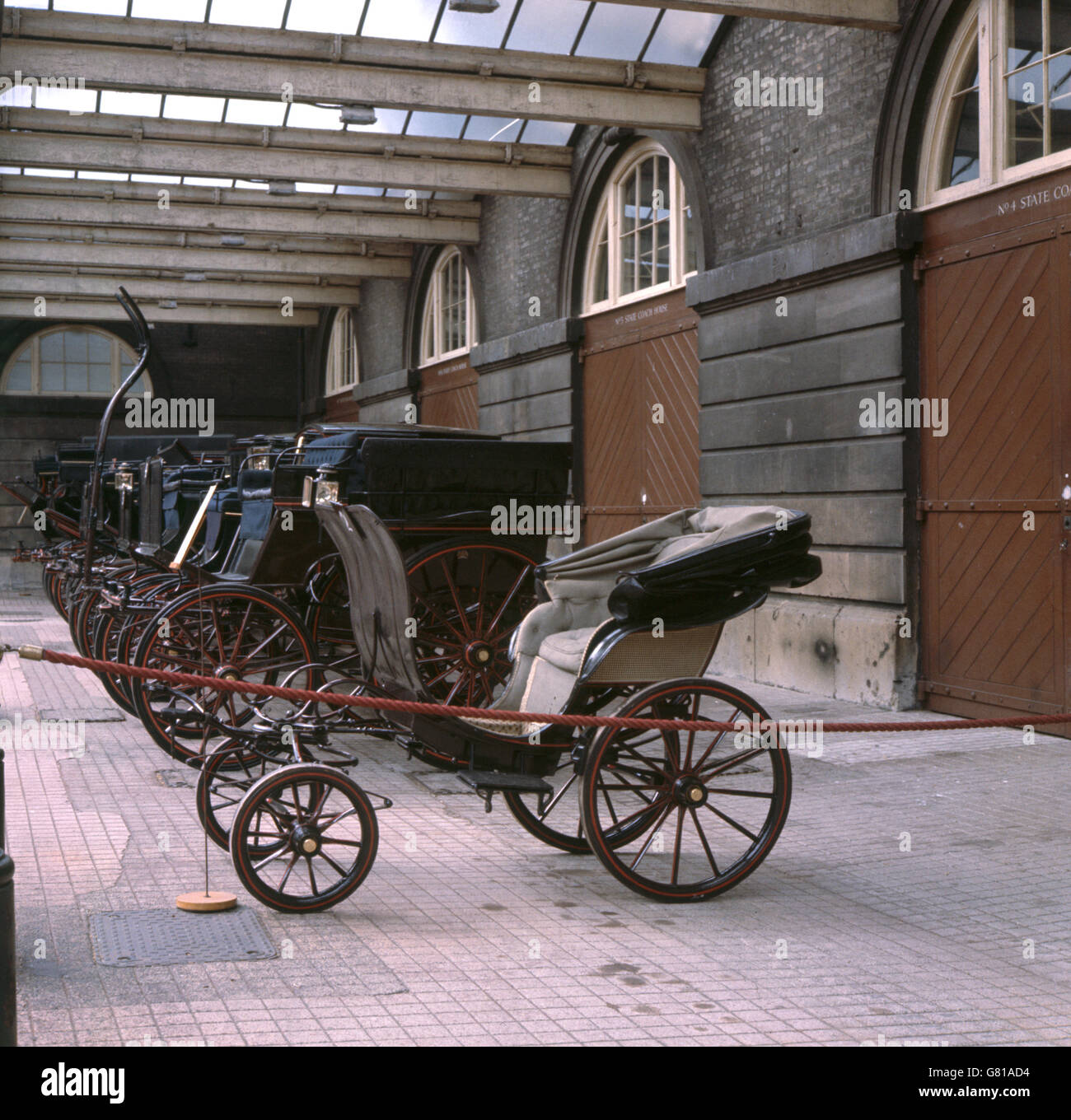 Eine Reihe hochglanzpolierter Transportmittel auf Rädern, die unter Abdeckung im Royal Mews, Buckingham Palace, London, geparkt wurden, als die Mews der Presse gezeigt wurden. Stockfoto