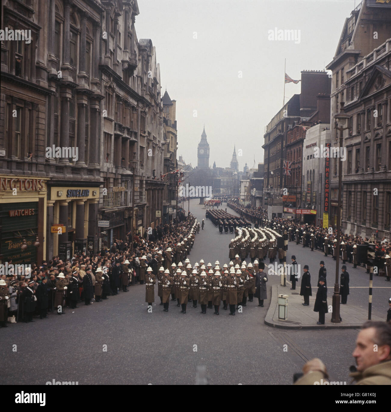 Eine Militärkapelle nähert sich von Whitehall aus dem Trafalgar Square mit den Houses of Parliament im Hintergrund. Stockfoto