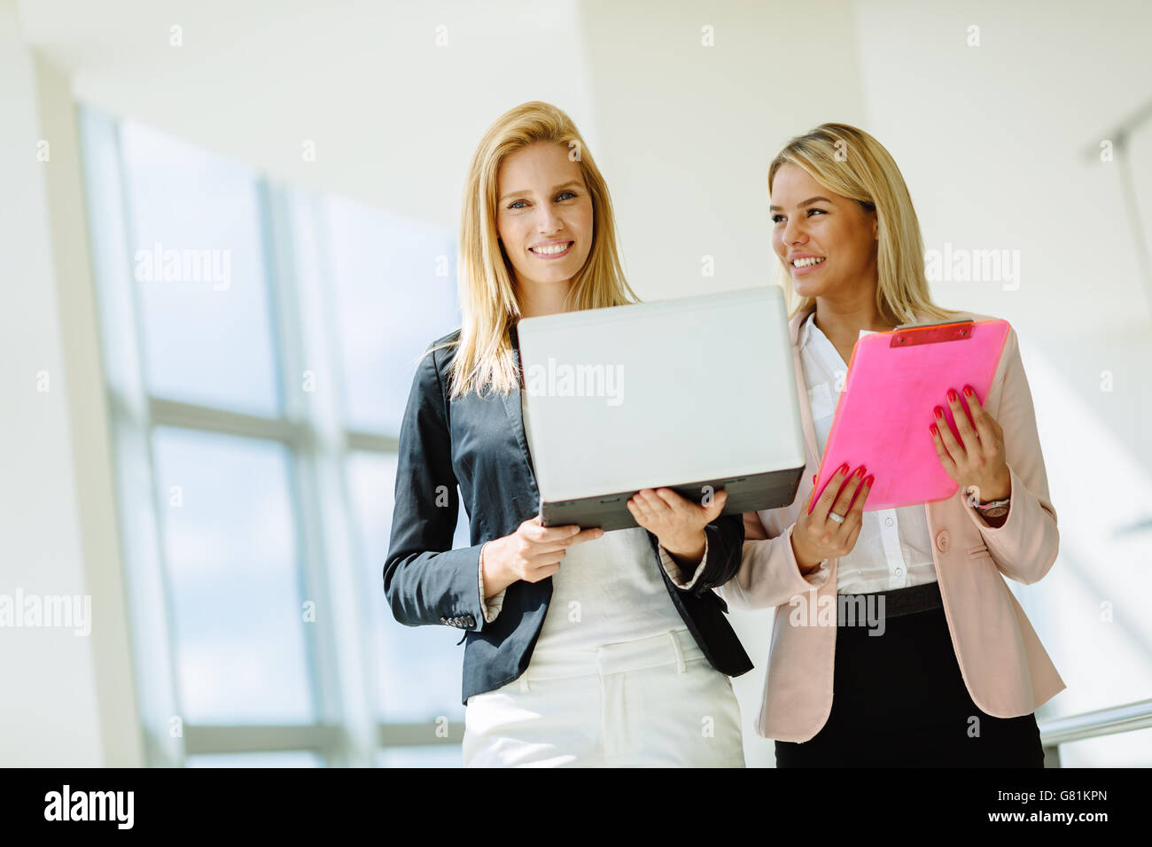 Geschäftsfrauen, die Pläne in Firmengebäude zu besprechen Stockfoto