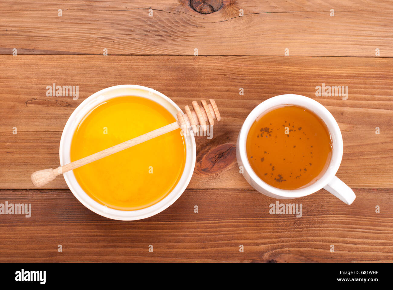 Tasse Tee und einen Teller mit Honig auf einem Holztisch. Stockfoto
