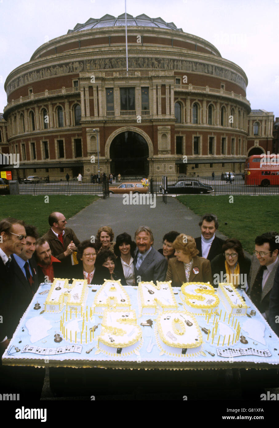 Der deutsche Bandleader James Last (Mitte, Streifen) mit der 200 Pfund schweren Torte, die ihm von Fans zu seinem 50. Geburtstag überreicht wurde. Im Hintergrund die Royal Albert Hall, London. Wo er ein Geburtstagskonzert gibt. Stockfoto