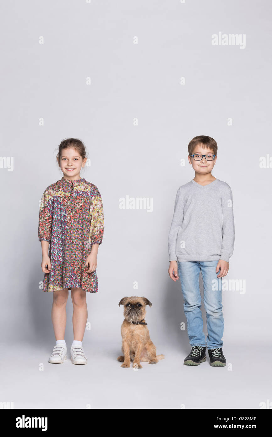 Porträt der Geschwister mit Hund vor weißem Hintergrund Stockfoto