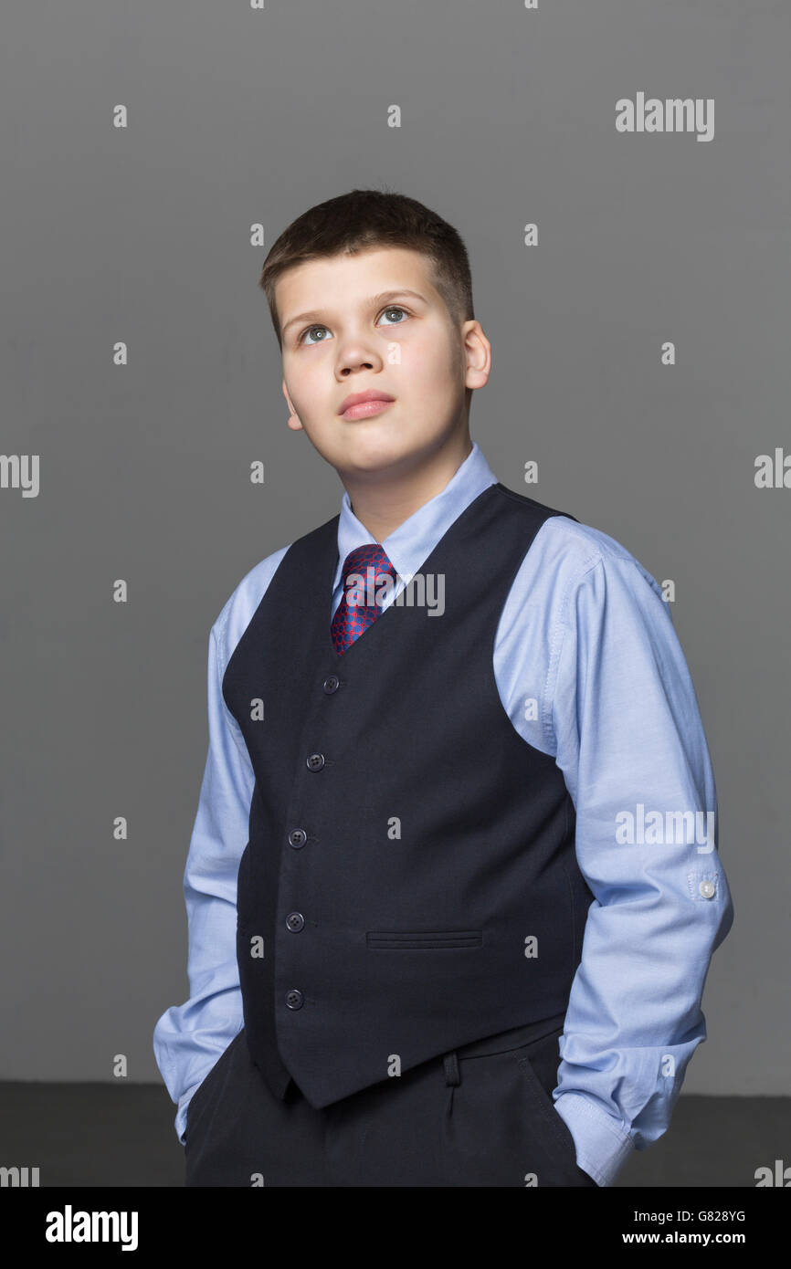 Überzeugt junge blickte stehend vor grauem Hintergrund Stockfoto