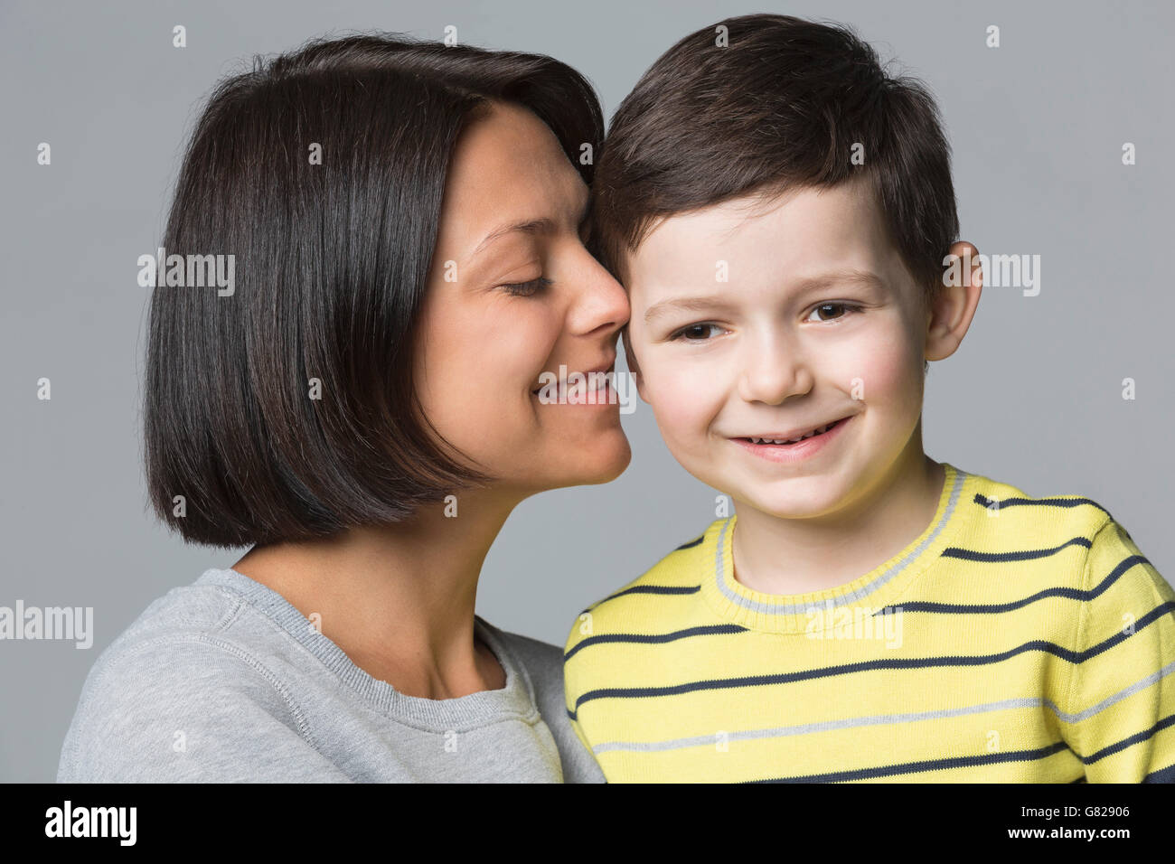 Nahaufnahme der liebende Mutter mit Sohn vor grauem Hintergrund Stockfoto