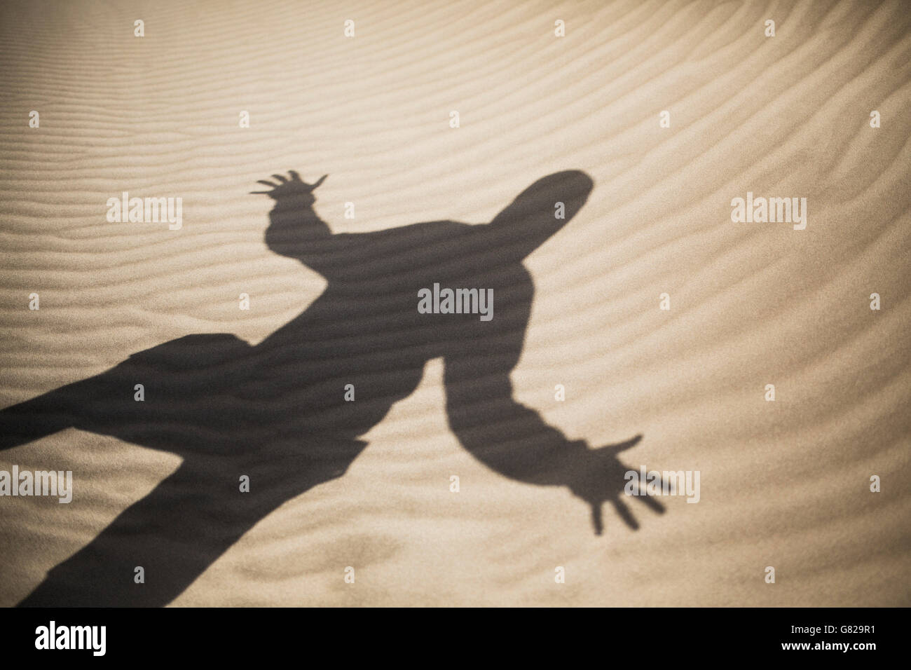 Schatten der Mann mit ausgestreckten auf sand Stockfoto