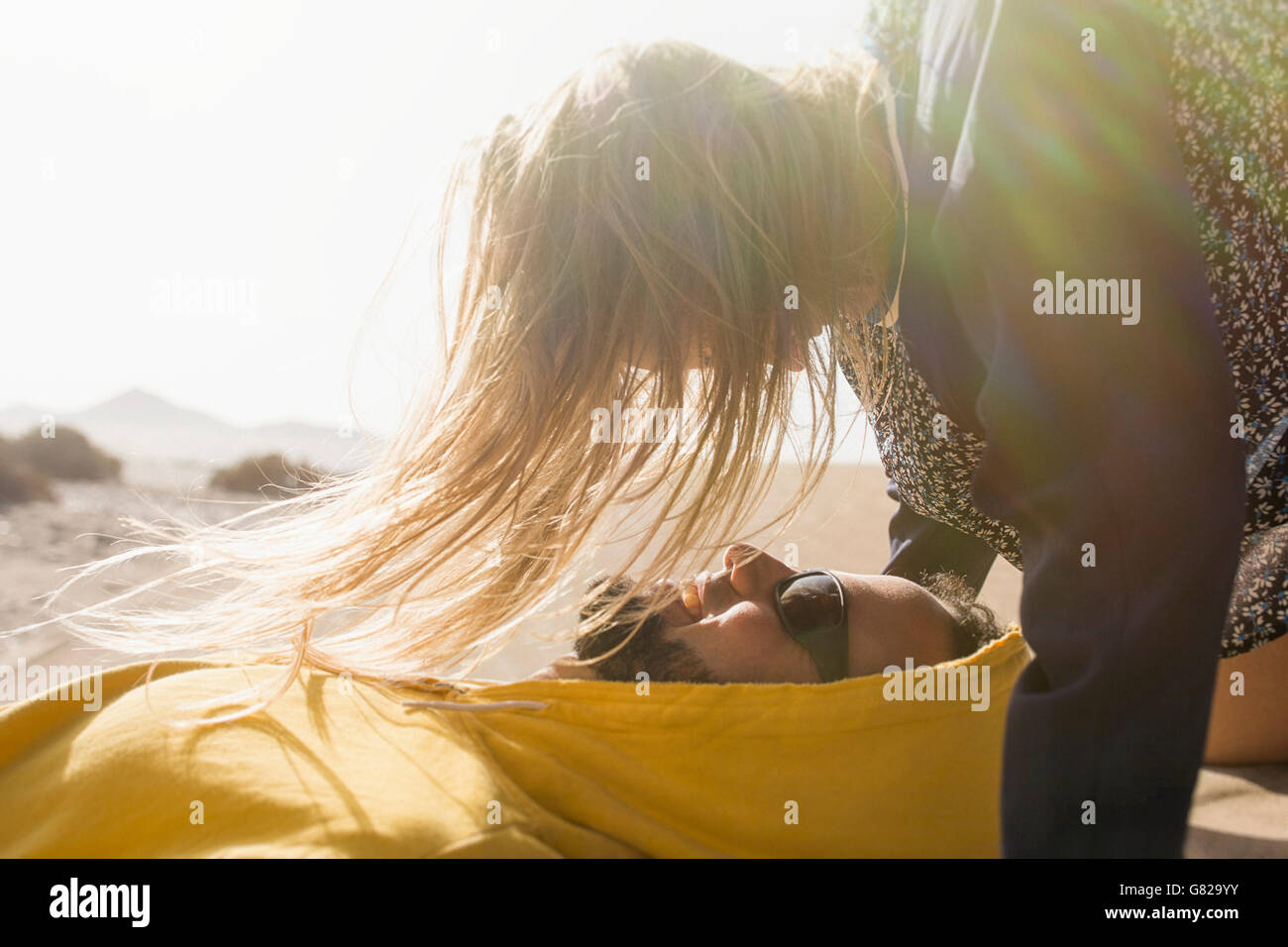 Romantische junge Frau Blick auf Menschen, die im Sommer auf Sand liegend Stockfoto