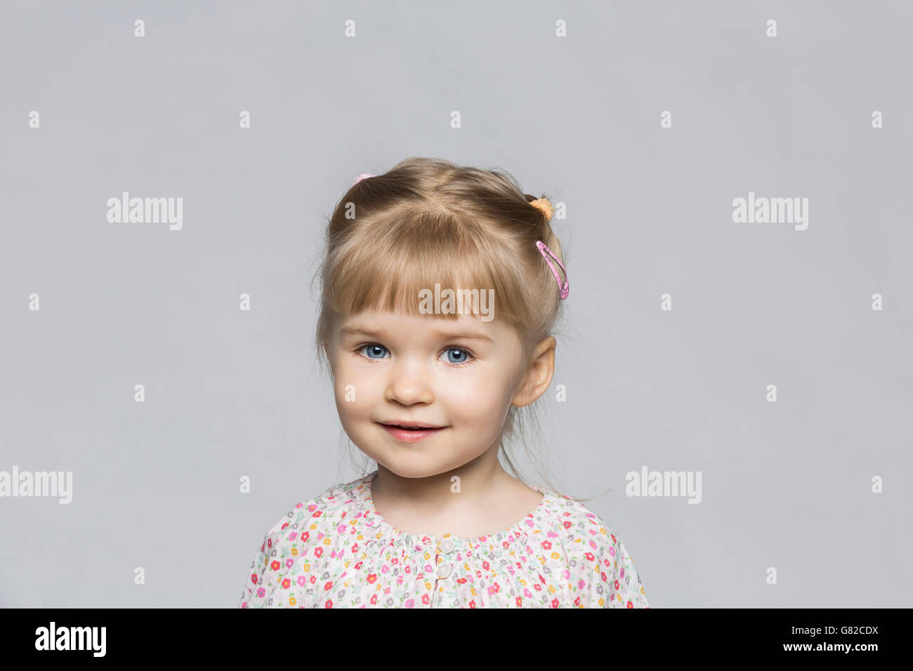 Porträt von lächelndes Mädchen vor grauem Hintergrund Stockfoto