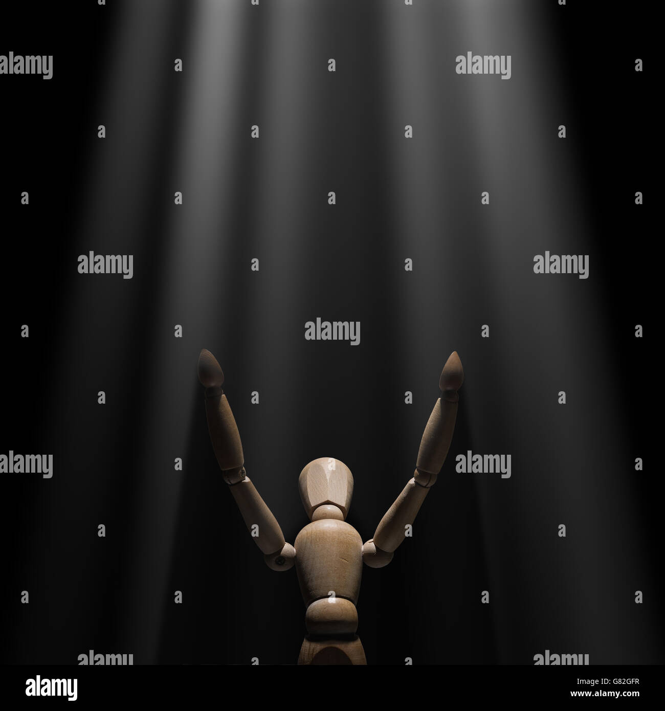 Hölzerne Puppe hob die Hände ans Licht Stockfoto