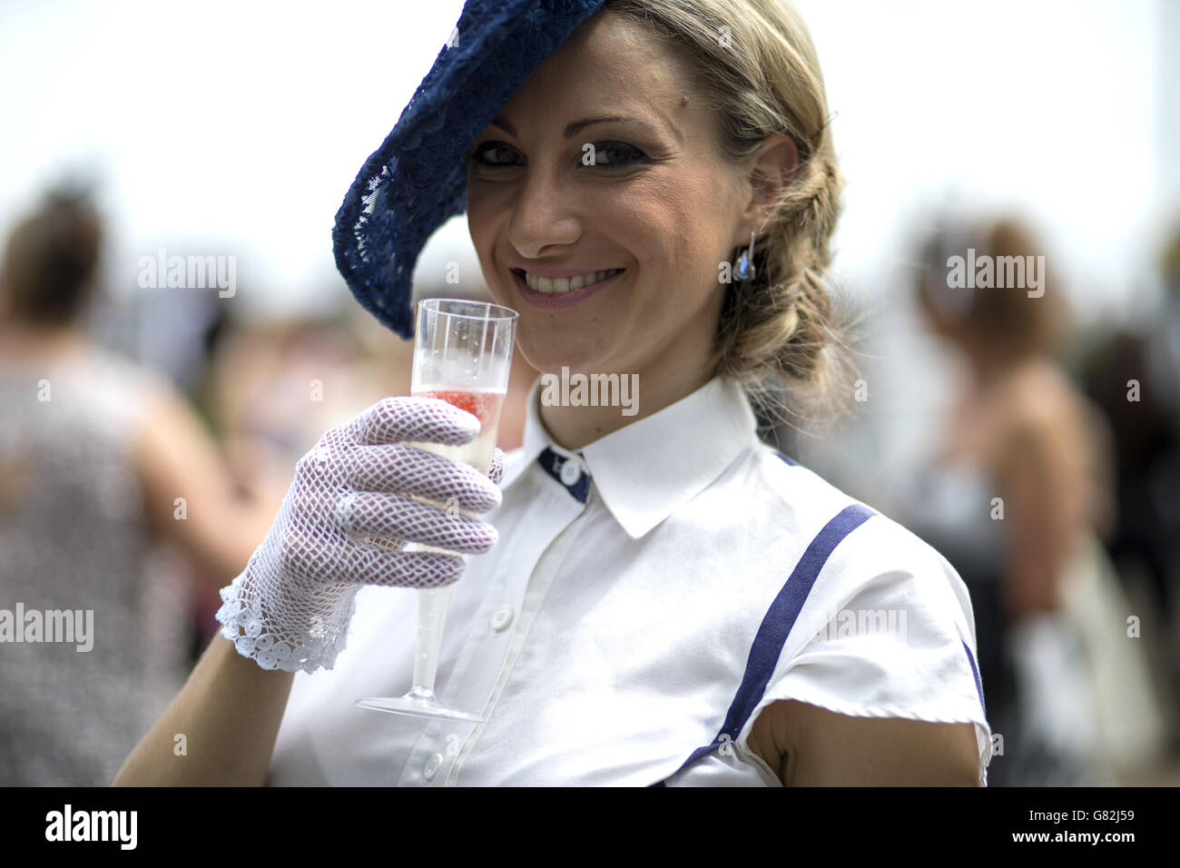 Pferderennen - 2015 Investec Derby Festival - Ladies Day - Epsom Racecourse. Beim Ladies Day des Investec Derby Festivals 2015 auf der Epsom Racecourse, Epsom, hält ein Rennfahrer einen Drink in einer Sektflöte. Stockfoto