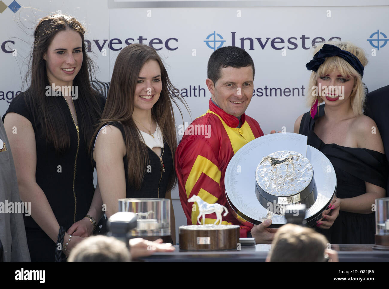 Der Jockey Colm O'Donoghue erhält am Ladies Day des Investec Derby Festivals 2015 auf der Epsom Racecourse in Epsom eine Trophäe, nachdem er sich für den Sieg in der Investec Oaks qualifiziert hat. Stockfoto