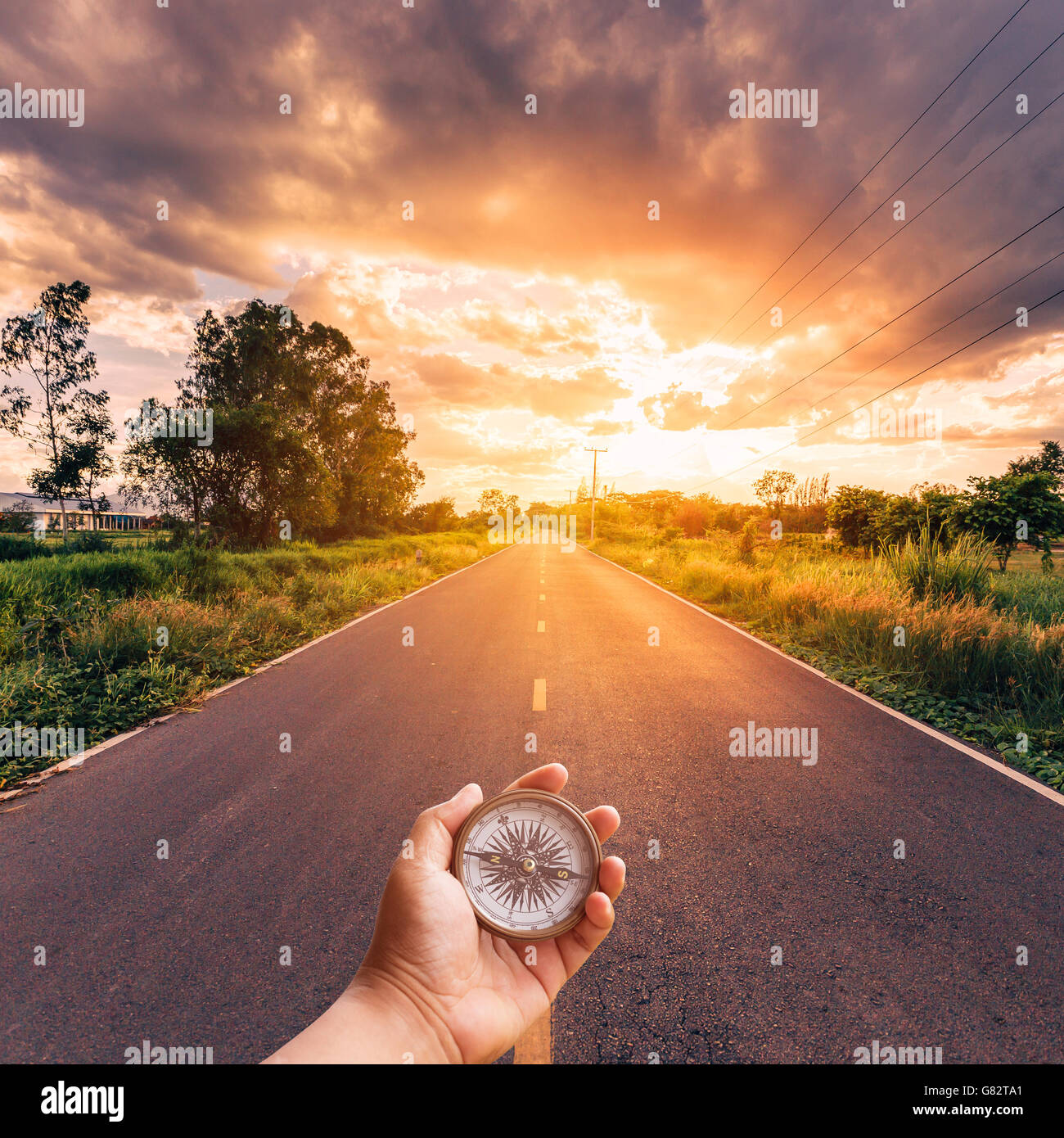 Hand-Mann, der Kompass mit Himmel Sonnenuntergang unterwegs. Stockfoto