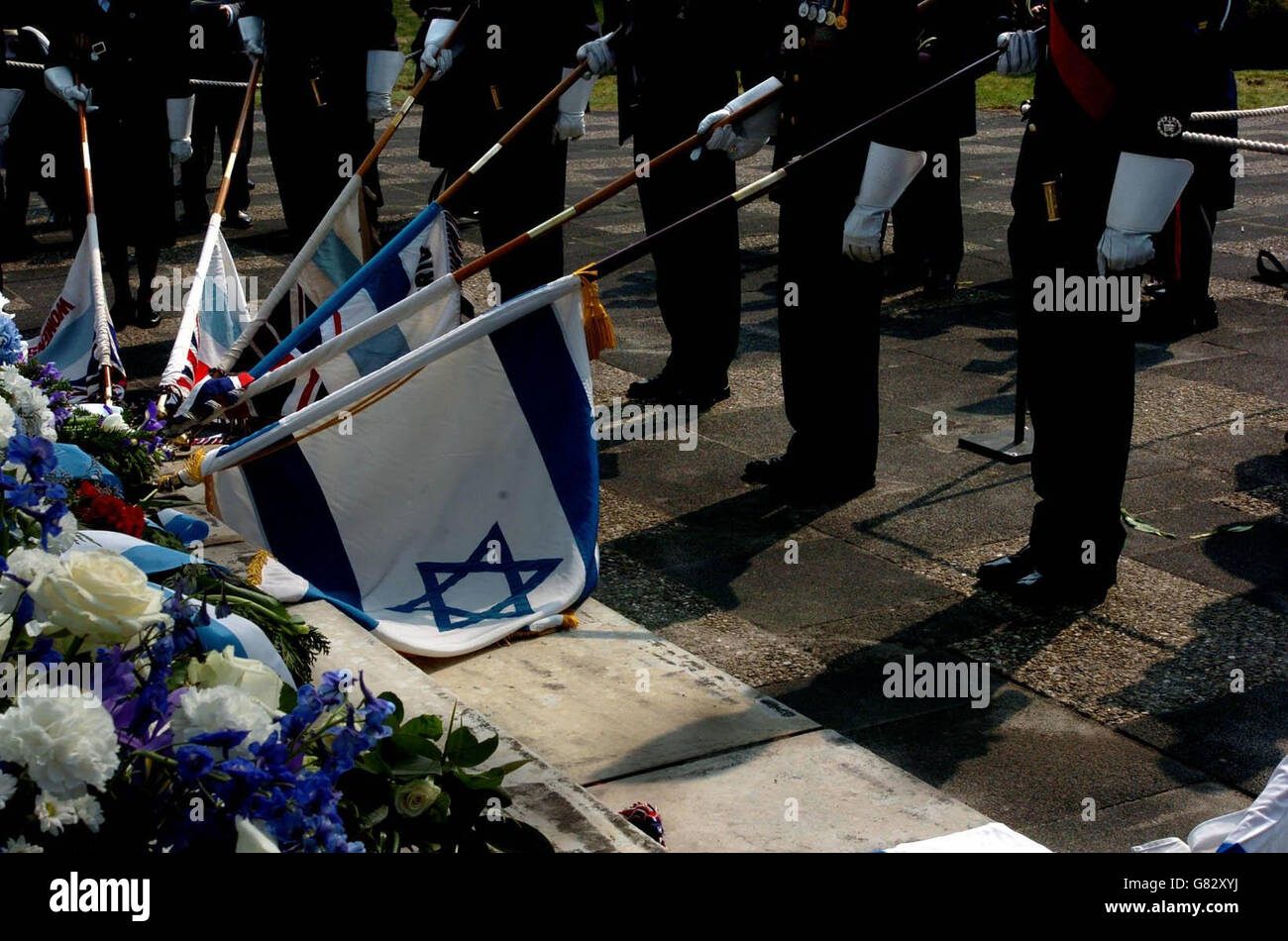 Während einer Gedenkfeier an der Gedenkstätte des ehemaligen Konzentrationslagers Bergen-Belsen werden die Standards gesenkt. Rund 200 Menschen nahmen an einem Gedenkgottesdienst anlässlich des 60. Jahrestages seiner Befreiung durch britische Truppen Teil. Stockfoto