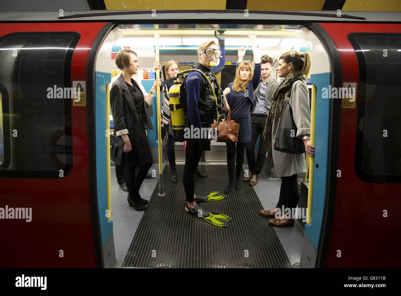 NUR zur redaktionellen Nutzung ein Schauspielers gekleidet wie eine Taucher seinen Weg durch die Londoner U-Bahn für Teletext Holidays-Sommer-Kampagne zum Start des Sommers macht Ferienzeit. Stockfoto