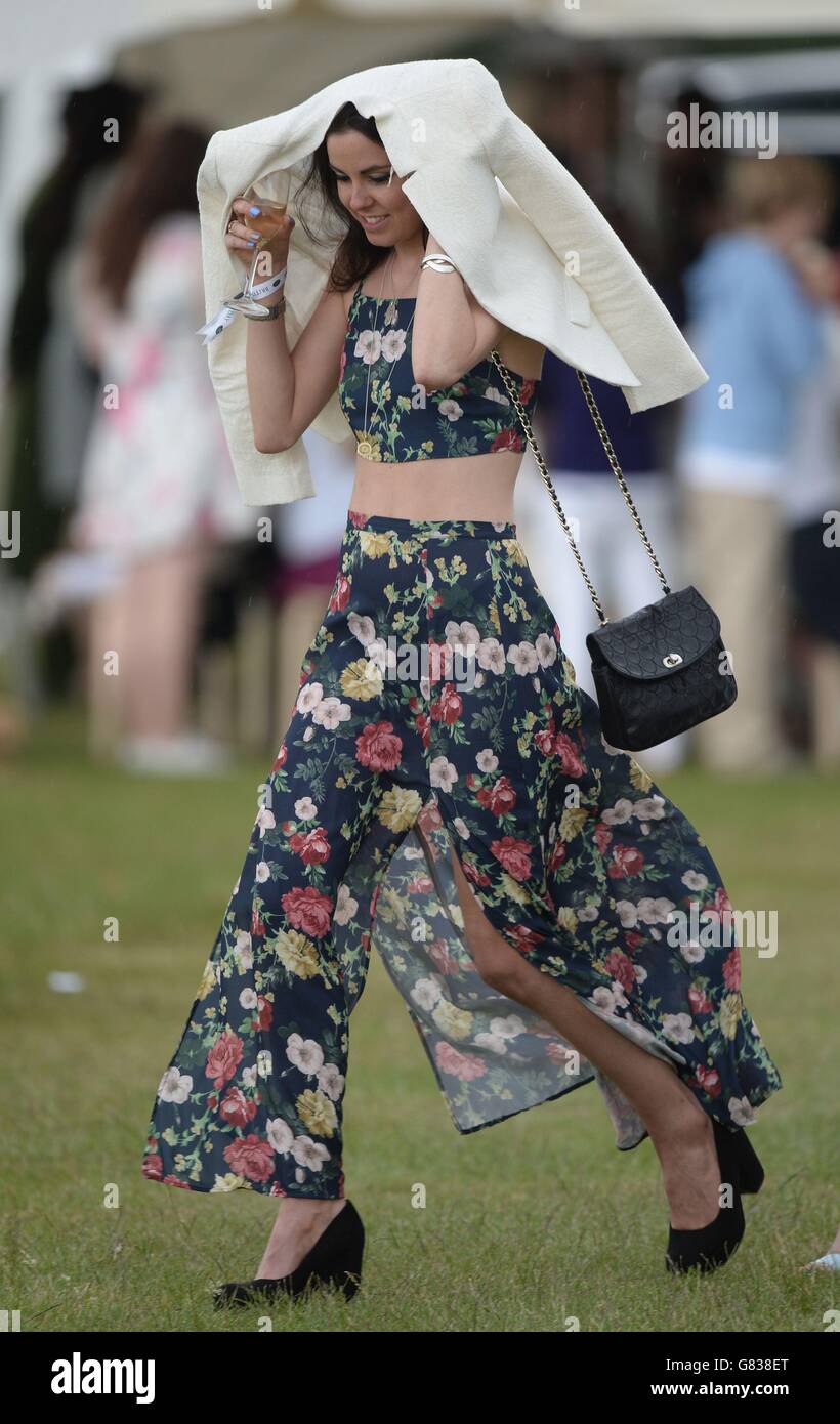 Die Gäste werden während des British Polo Day in Henley-on-Thames, Oxfordshire, von Regen bedeckt. Stockfoto