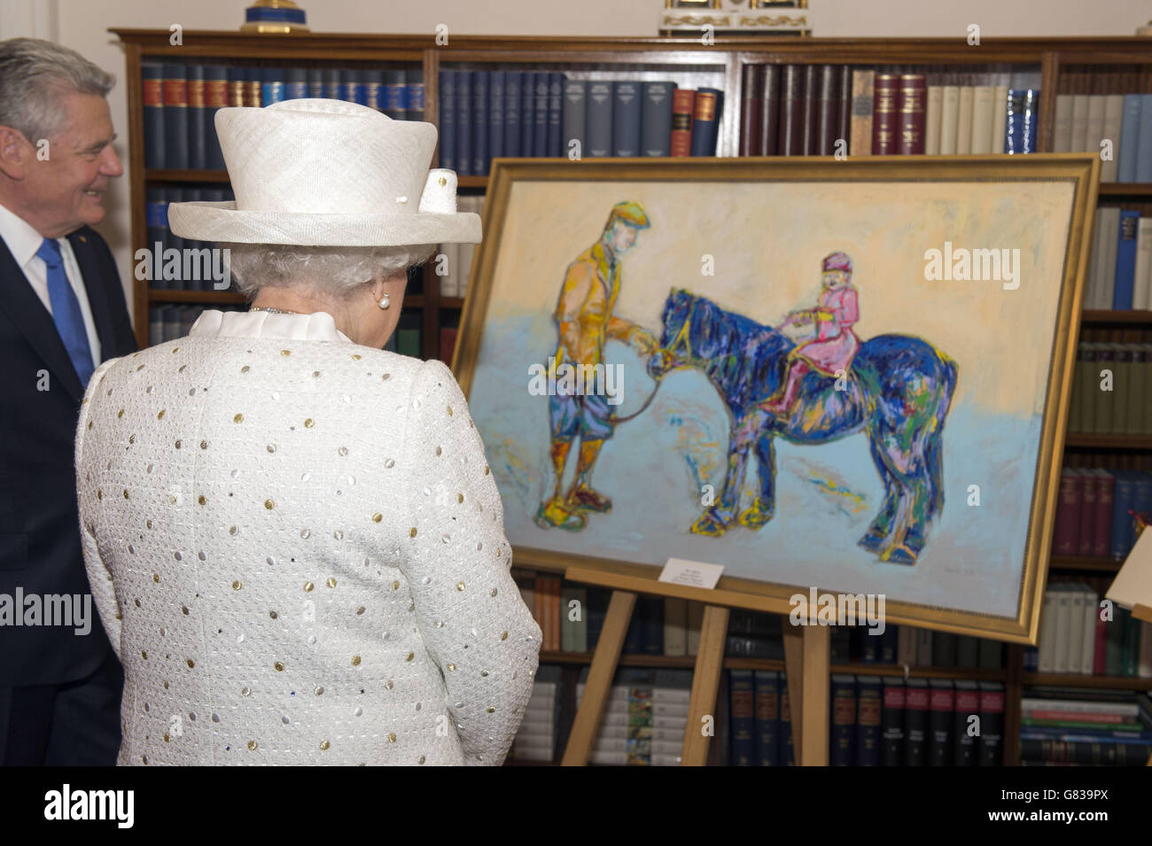 Königin Elisabeth II. Wird am ersten vollen Tag ihres Staatsbesuches in Deutschland in seiner offiziellen Berliner Residenz, Schloss Bellevue, ein Gemälde von Bundespräsident Joachim Gauck überreicht. Das stilisierte Gemälde der Königin, die auf einem Pony saß, veranlasste den Monarchen zu erklären, "das ist eine lustige Farbe für ein Pferd", als der deutsche Präsident ihr das Kunstwerk übergab. Stockfoto
