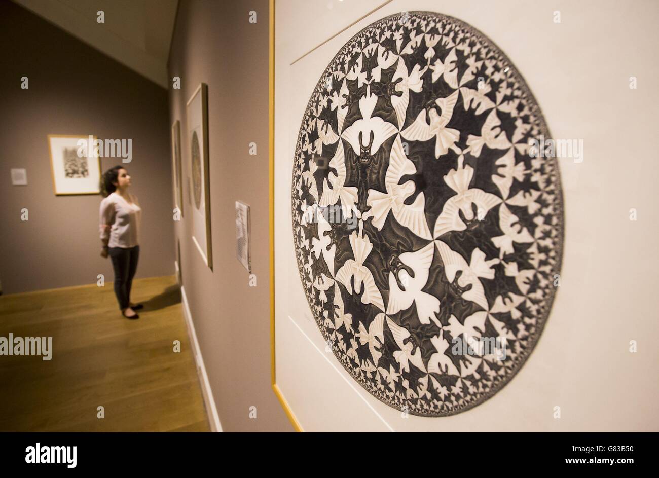 Die Mitarbeiterin der National Galleries of Scotland Adeline Amar mit einer Arbeit von M.C. Escher im Vorfeld einer großen Retrospektive der Künstler in der Scottish National Gallery of Modern Art in Edinburgh. Stockfoto
