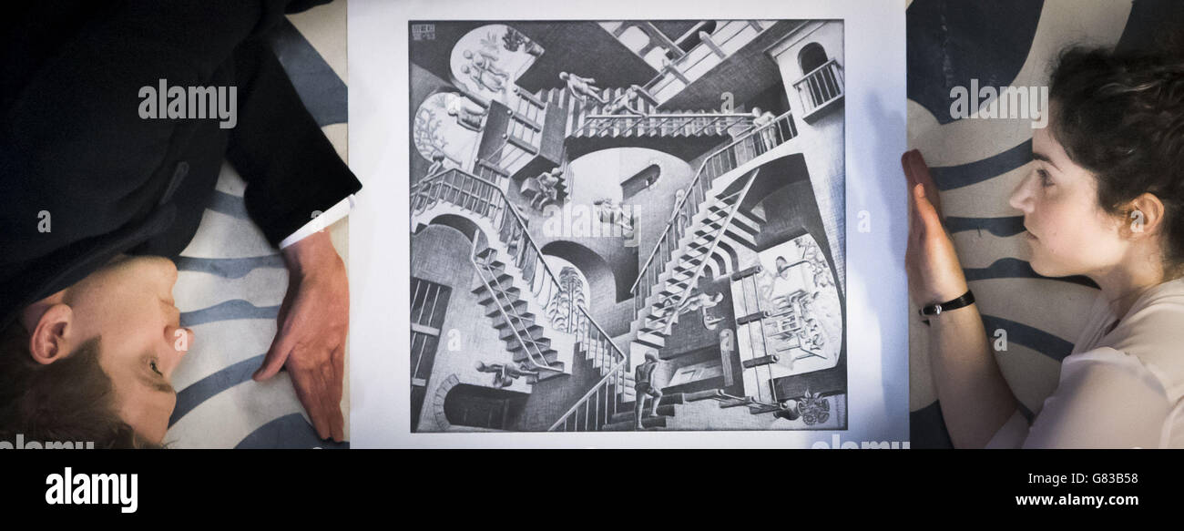 Die Mitarbeiter von National Galleries of Scotland, Harris Brine und Adeline Amar, erhalten einen Druck einer Arbeit von M.C. Escher im Vorfeld der großen Retrospektive der Künstler in der Scottish National Gallery of Modern Art in Edinburgh. Stockfoto