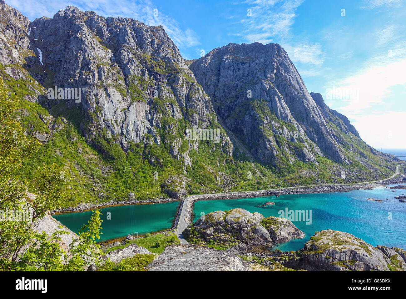 Schmale Straße zwischen Meer und Bergen, Henningsvær, Lofoten, mit blauen Meer dn Damm Stockfoto