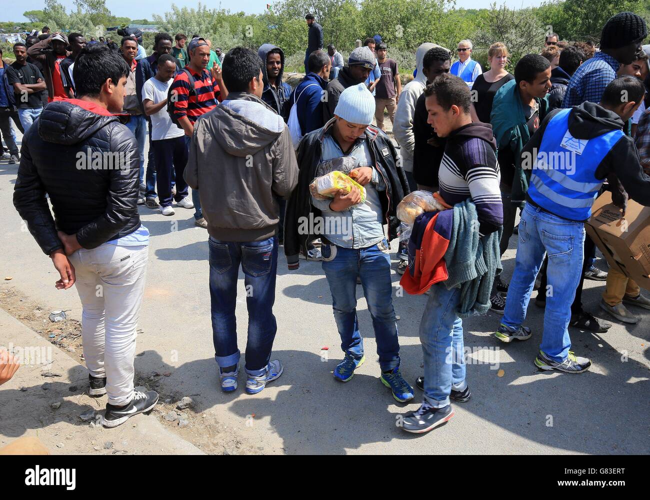 Migranten warten in einem kargen Lager namens "der Dschungel II" in Calais, Frankreich, an, um gespendete Lebensmittel zu sammeln, während die Migrationskrise in ganz Europa weiter eskaliert. Stockfoto