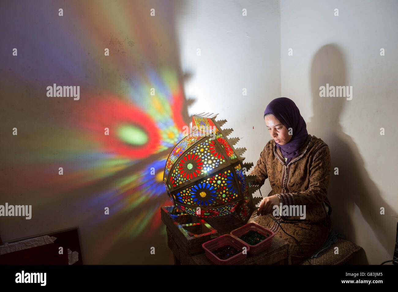Ein Handwerker schafft traditionelle Leuchten in ihrem Atelier in Fez, Marokko. Stockfoto
