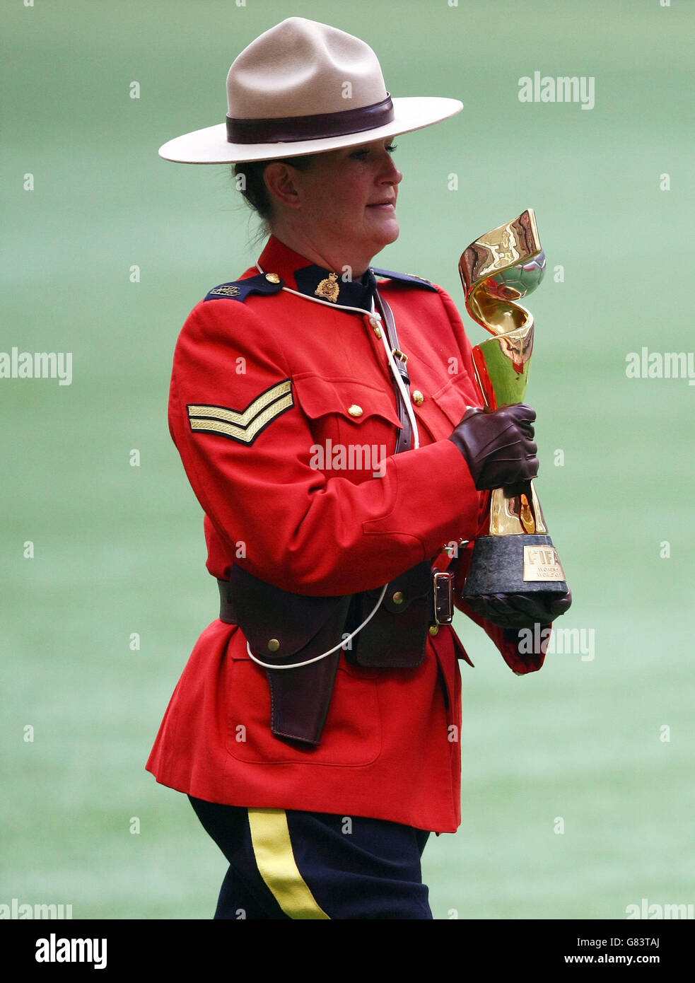 Die FIFA Frauen-Weltmeisterschaft wird nach dem Finale der FIFA Frauen-Weltmeisterschaft Kanada 2015 zwischen den USA und Japan im BC Place Stadium in Vancouver, Kanada, von einem kanadischen Mountie auf das Spielfeld gebracht. Stockfoto