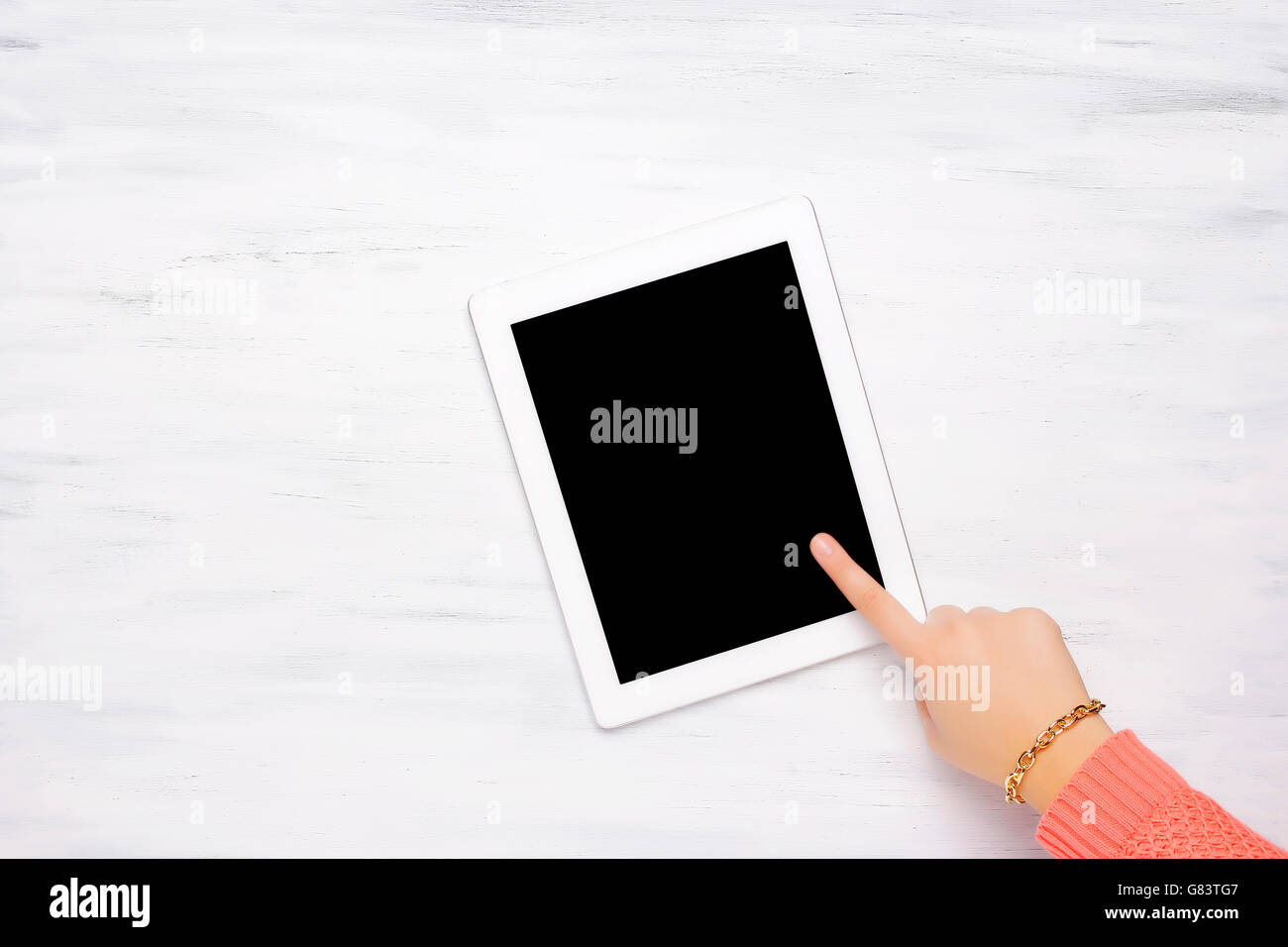 Frau zeigt etwas in einem Tablet-Gerät auf einem Holztisch mit Büroartikel. Ansicht von oben mit Exemplar. Stockfoto