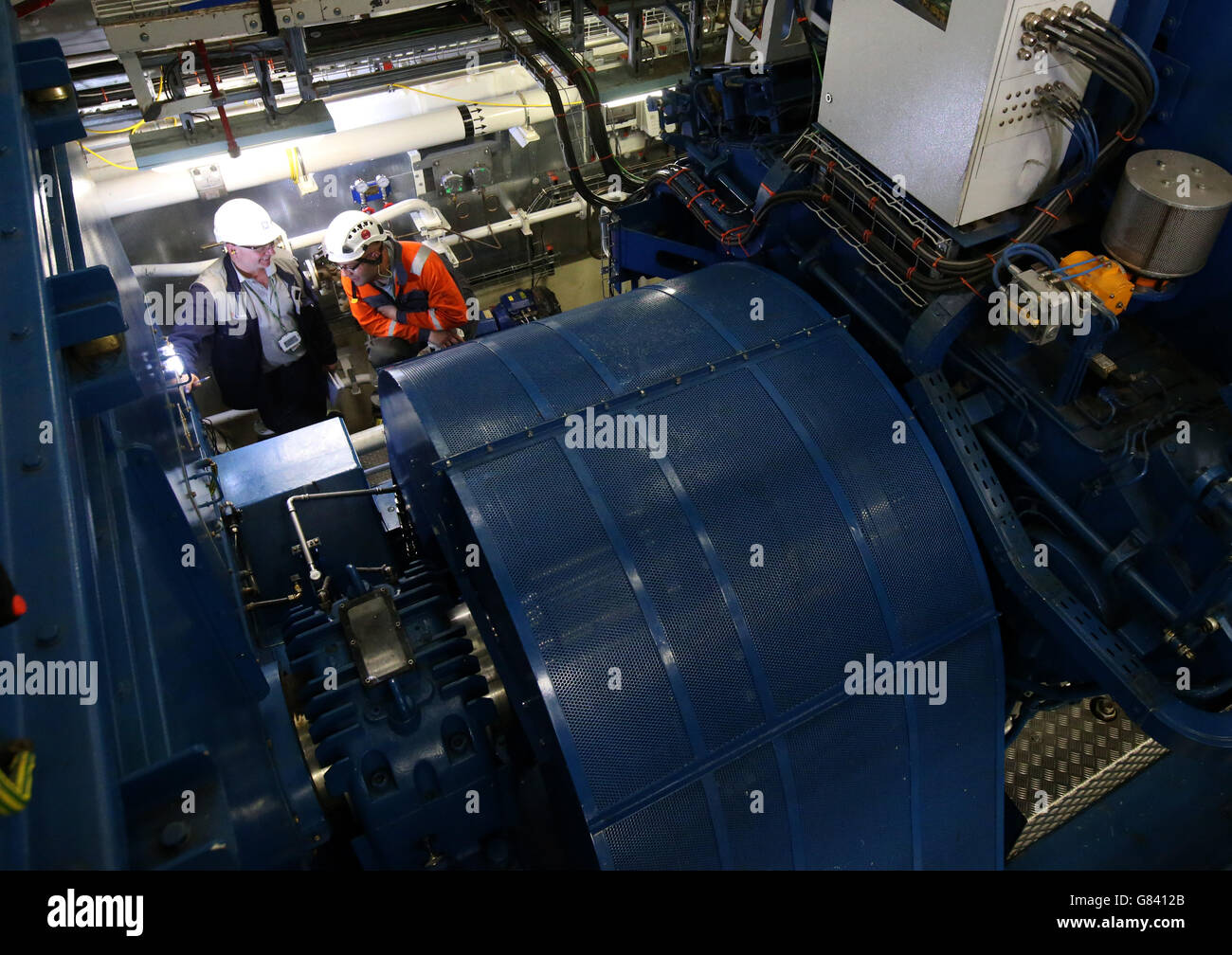 Arbeiter sehen den Dieselgenerator im Achtermotorenraum von HMS Queen Elizabeth auf der Rosyth Dockyard in Fife, nachdem das größte Kriegsschiff, das je in Großbritannien gebaut wurde, zum ersten Mal Strom aus seinen Dieselgeneratoren an Bord produzierte. Stockfoto