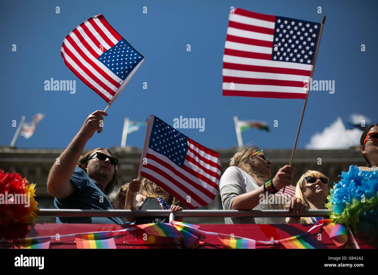 Menschen auf einen Bus, gesponsert von der US-Botschaft im Vereinigten Königreich, Welle US Flaggen, wie sie an der London Pride Parade 2015 im Zentrum von London teilnehmen. Samstag, 27. Juni 2015. Daniel Leal Olivas/PA Wire Stockfoto