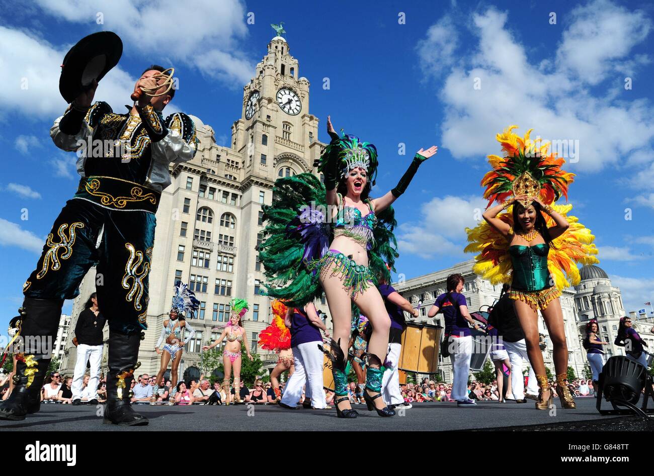 Tänzer in aufwendigen Kostümen nehmen am Very Big Catwalk am Pier Head in Liverpool Teil, um den Weltrekord für den größten Catwalk aller Zeiten zu brechen. Stockfoto