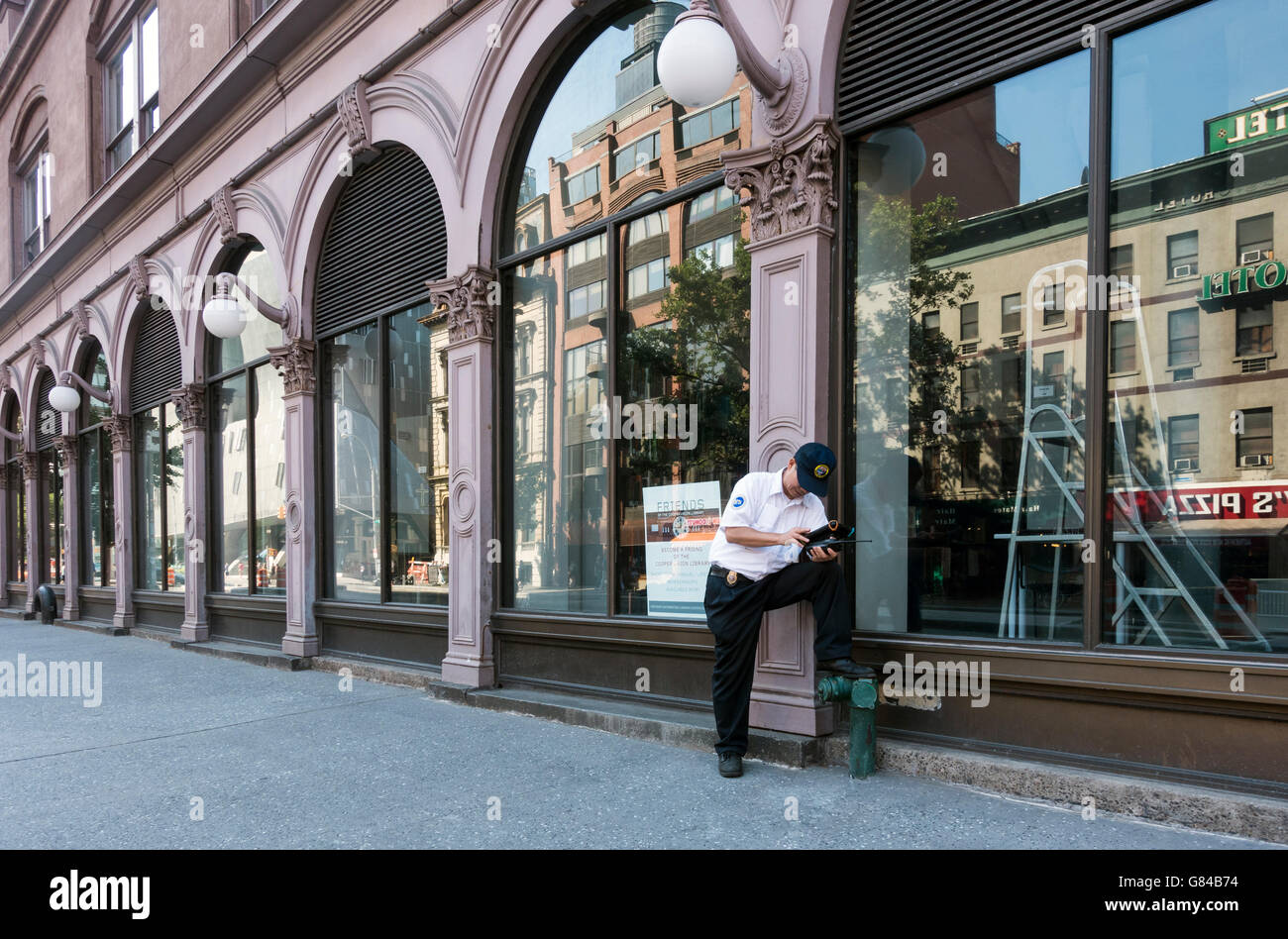 MTA Bus Manager überprüfen seinen Fahrplan vor der Foundation Building in der Nähe von Astor Place in der East Village, New York City Stockfoto