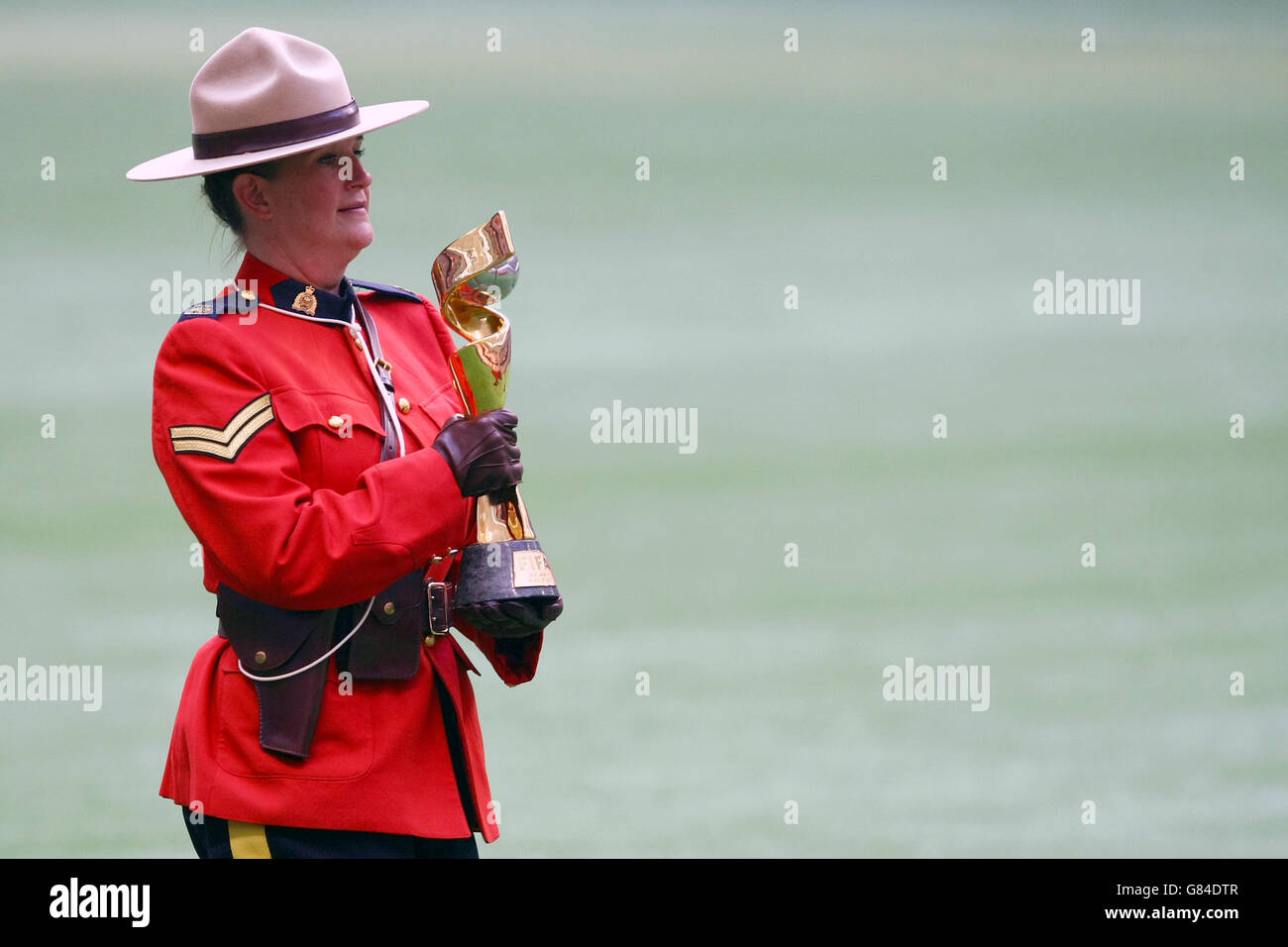 Die FIFA Frauen-Weltmeisterschaft wird nach dem Finale der FIFA Frauen-Weltmeisterschaft Kanada 2015 zwischen den USA und Japan im BC Place Stadium in Vancouver, Kanada, von einem kanadischen Mountie auf das Spielfeld gebracht. Stockfoto